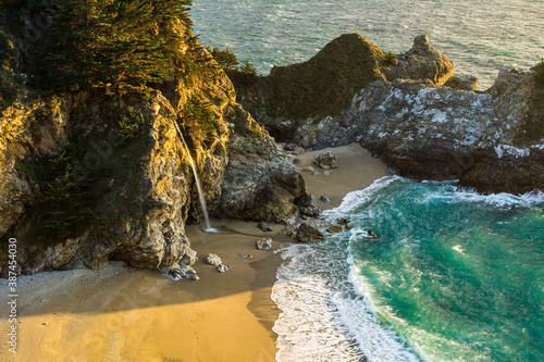 McWay Falls empties onto the beach in Big Sur at sunset photo