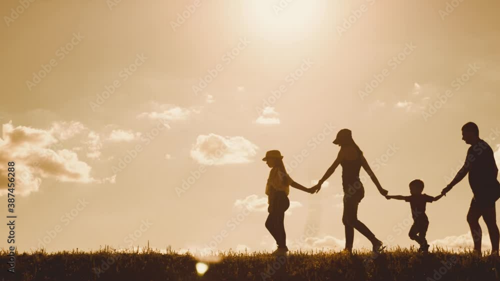 Happy family walking in field on sunny day. Concept of friendly family. Happy family walking in field on sunny day. Concept of friendly family.