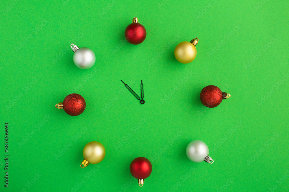 Top view of Christmas watch with colorful balls on the green background Top view of Christmas watch with colorful balls on the green background