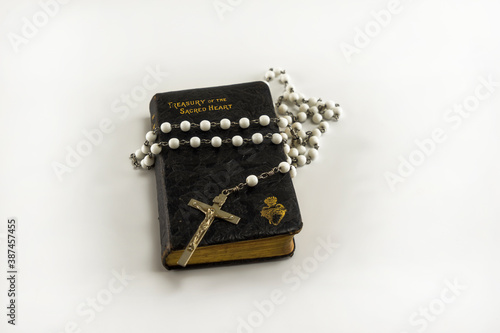 Catholic holy prayer book Treasury of the Sacred Heart and white beads crucifix with holy cross isolated on a white background