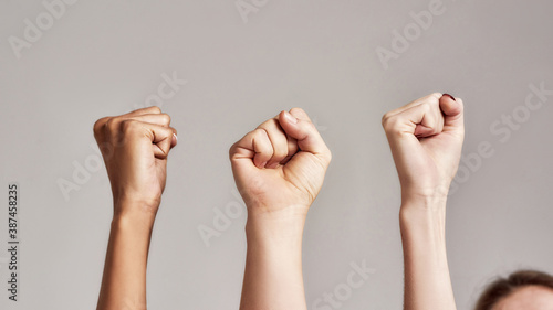 Close up of three raised fists of diverse women. Feminism, equality and women liberation concept