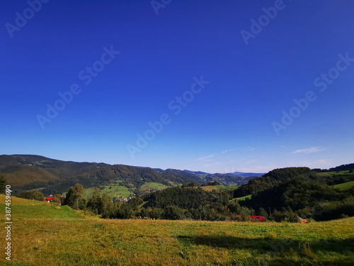 View of the green meadow against the blue sky. Beskidy Mountains Poland.