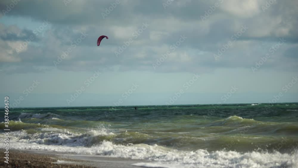 Kiteboarder enjoys sports in the sea with parachutes, Kiteboarding. Concept of active recreation, water sports. Kiteboarder enjoys sports in the sea with parachutes, Kiteboarding. Concept of active recreation, water sports.