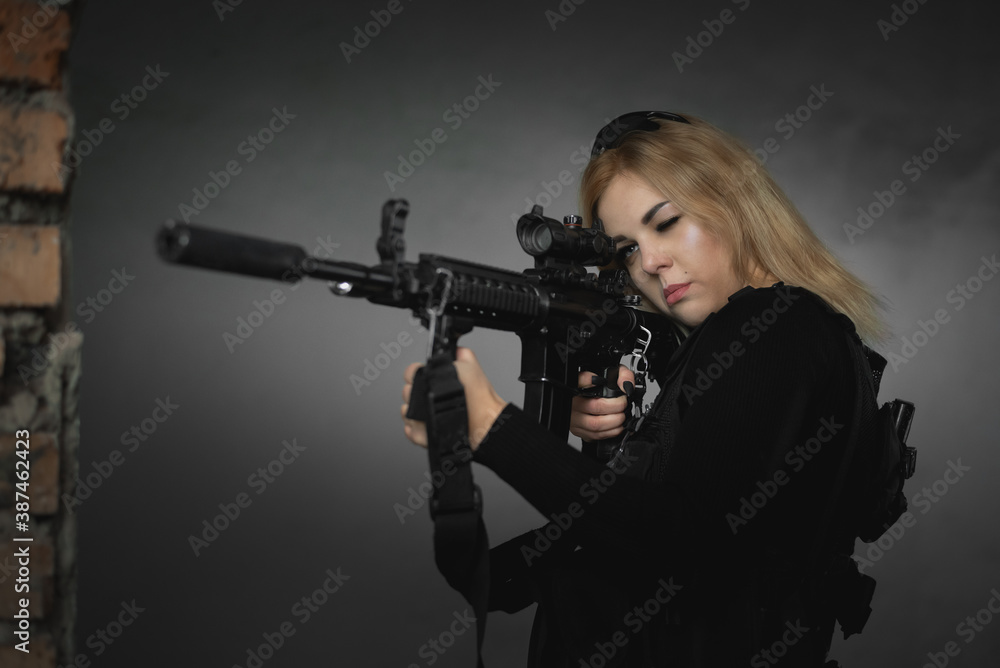 A girl soldier with a rifle in abandoned building.