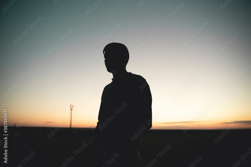 silhouette of a man on a sunset background. Male profile