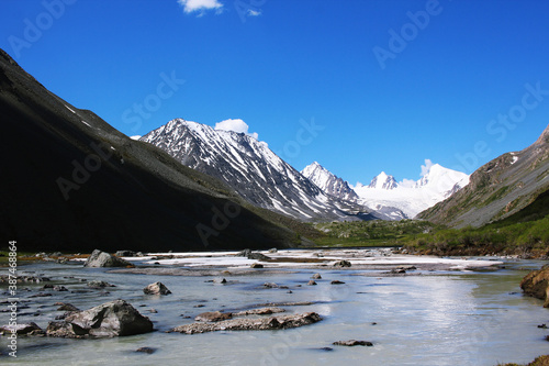 The river is surrounded by mountains covered with snow. Sophia glacier is visible in the distance