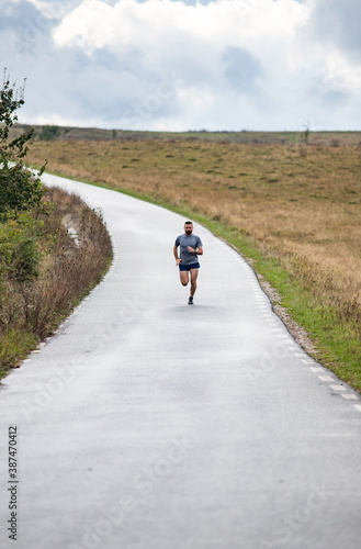 young man running on country road