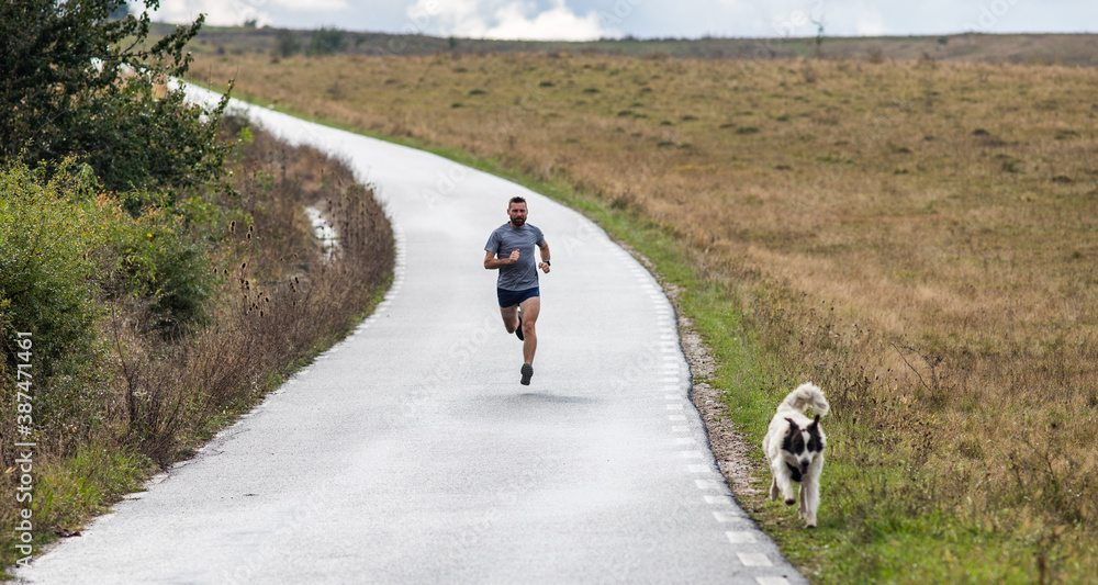 Obraz premium young man running on country road
