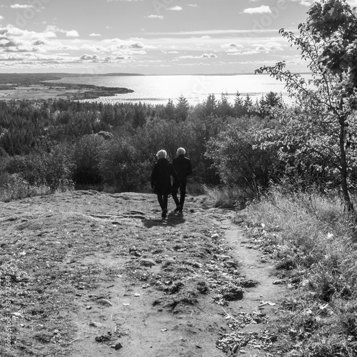 Senior couple walking down Omberg mountain with view of Lake Vättern © jimmagini