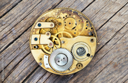 Fotografía Antique metal pocket watch clockwork with gears on wooden background