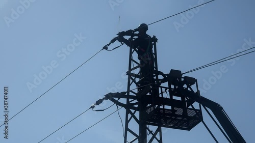 Electrician checking fixing broken electric wire on pole.