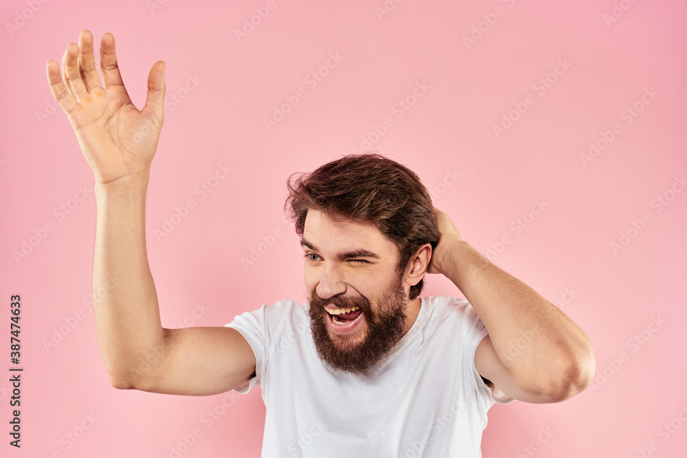 Man in white t-shirt gestures with hands emotions lifestyle cropped view pink background Man in white t-shirt gestures with hands emotions lifestyle cropped view pink background