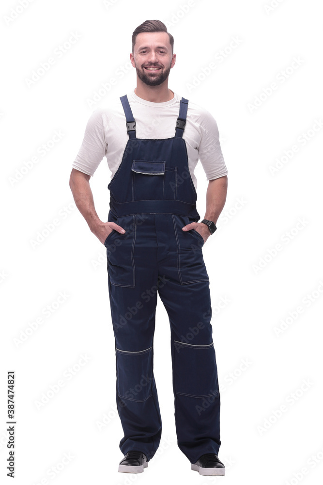 in full growth. smiling man in overalls. in full growth. smiling man in overalls.