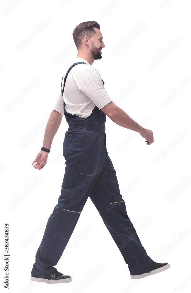 side view. smiling man in overalls confidently striding forward side view. smiling man in overalls confidently striding forward