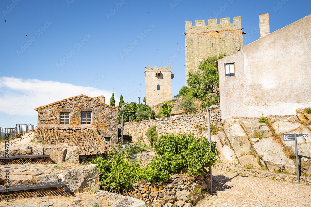 a street with old houses and the two castle towers at Pinhel city, Guarda district, Beira Alta province, Portugal