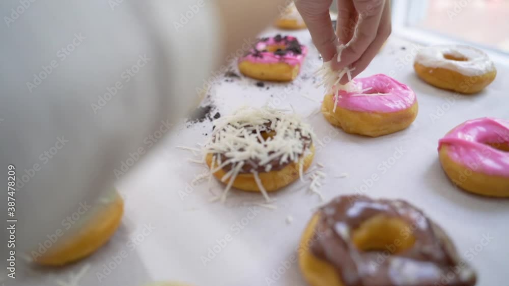 close up gesture of hand making and decorating homemade donuts close up gesture of hand making and decorating homemade donuts