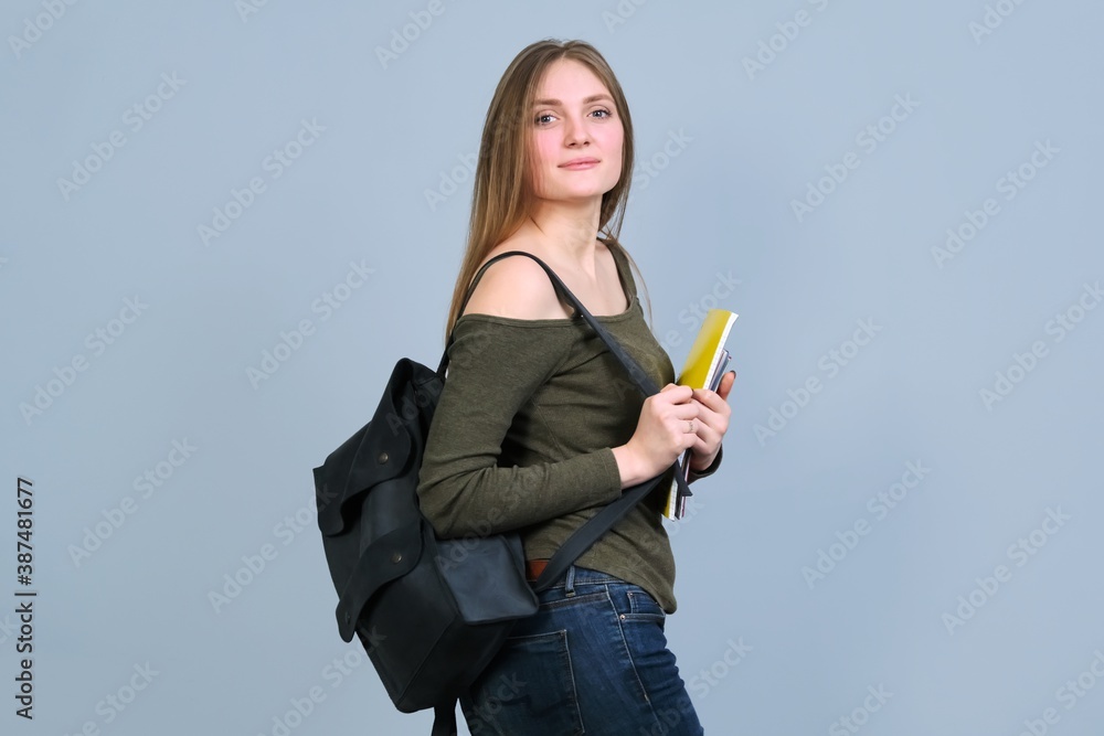 Portrait of smiling university student with backpack on gray background Portrait of smiling university student with backpack on gray background