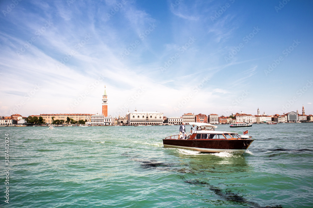 A hotel river shuttle cruises along Venice's Grand Canal on a summers day