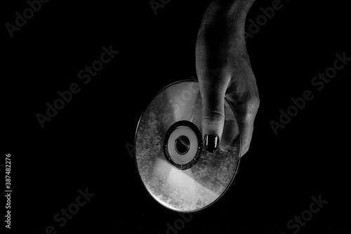 Black and white female hands holding a CD