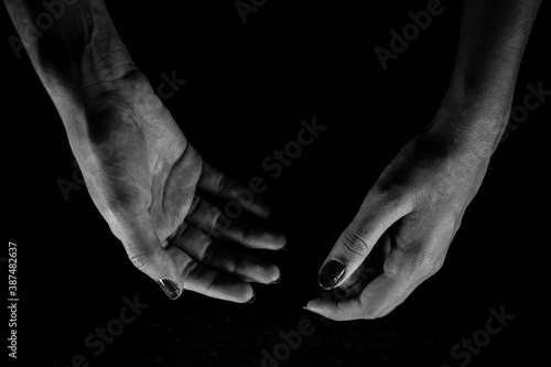 Butterfly-shaped female hands with a dark background black and white