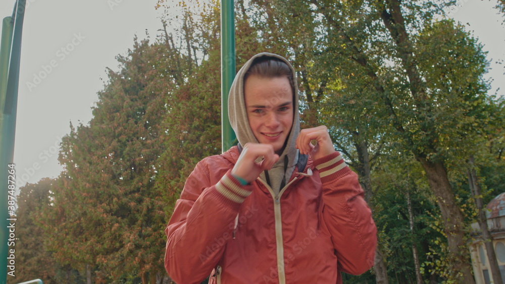 Face Of Young Sports Guy With . Guy Is Standing On The Street. Young Athletic Guy Makes First Movements As If Boxing. Face Of Young Sports Guy With . Guy Is Standing On The Street. Young Athletic Guy Makes First Movements As If Boxing.