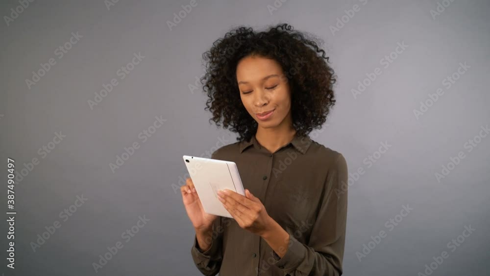 young cute mixed race woman with tablet. on an isolated gray background, 4K young cute mixed race woman with tablet. on an isolated gray background, 4K
