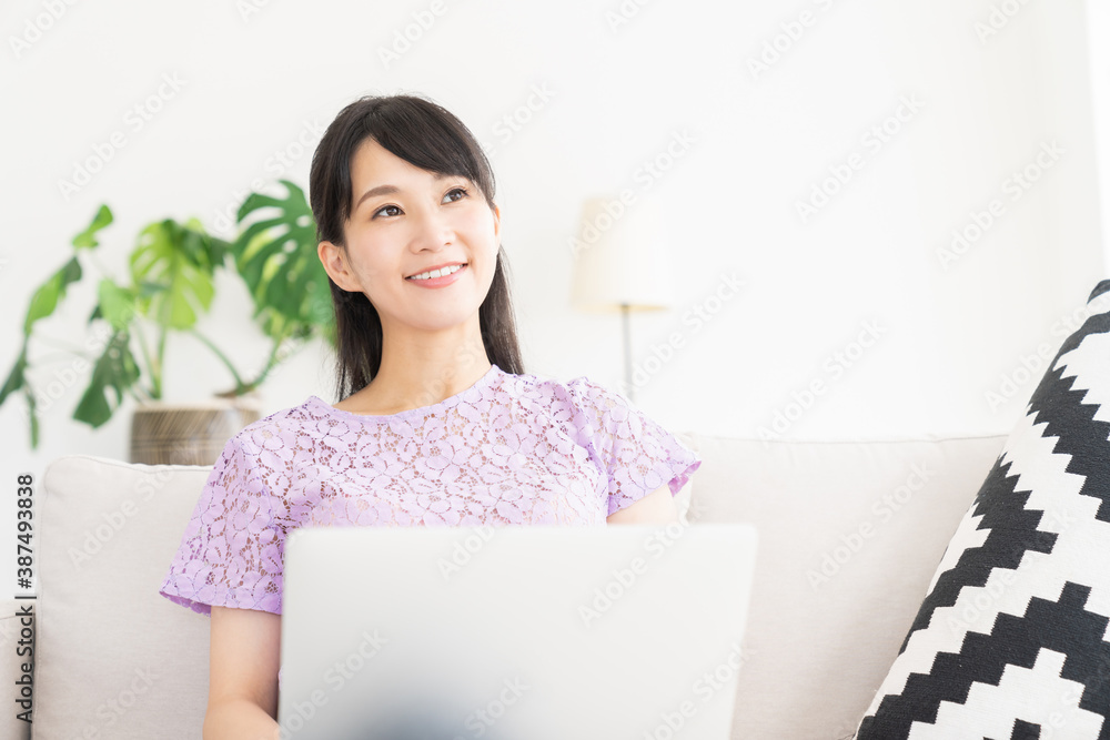 部屋でラップトップコンピューターを見る女性