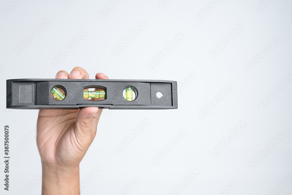 Hand holding spirit level tool for building or construction Hand holding spirit level tool for building or construction