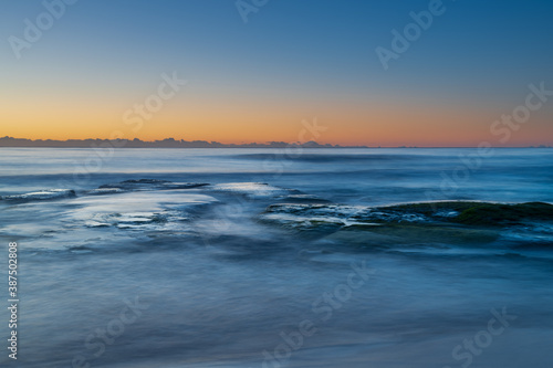 Clear skies and soft seas  dawn at the beach