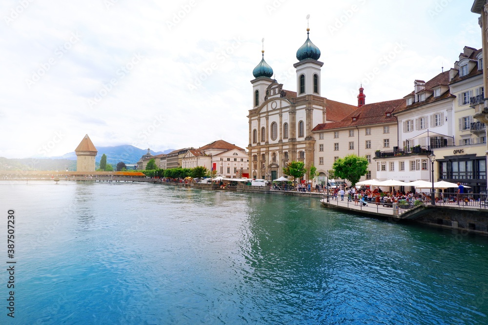 Lucerne, Switzerland - June 15, 2019 : City centre of old town Lucerne with restaurant, crowd and famous chapel bridge with clear blue crystal river of Lucerne, Vierwaldstattersee, Switzerland