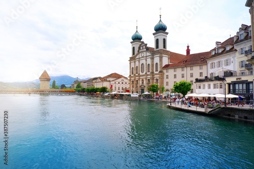 Lucerne, Switzerland - June 15, 2019 : City centre of old town Lucerne with restaurant, crowd and famous chapel bridge with clear blue crystal river of Lucerne, Vierwaldstattersee, Switzerland