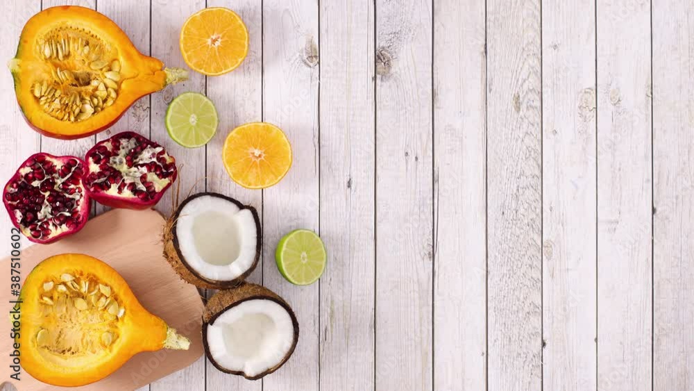 Sliced tropic and citrus ripe fruits appear on left side of wooden theme. Stop motion Sliced tropic and citrus ripe fruits appear on left side of wooden theme. Stop motion