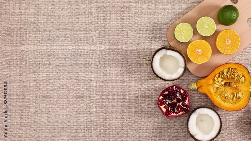 Sliced tropic and citrus fruits appear with cutting board on the table. Stop motion Sliced tropic and citrus fruits appear with cutting board on the table. Stop motion