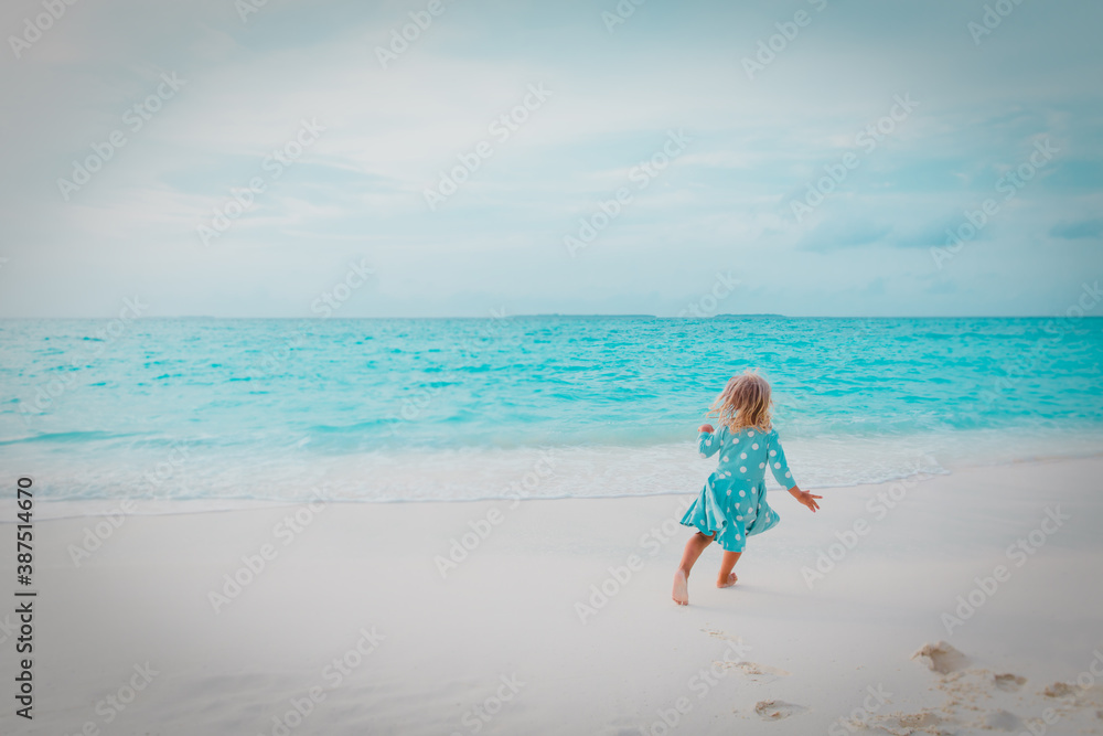 happy little girl run and play on tropical beach