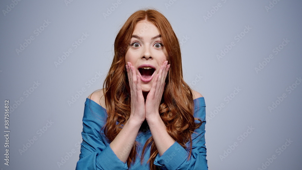Surprised woman opening mouth on gray background. Cute girl posing in studio Surprised woman opening mouth on gray background. Cute girl posing in studio