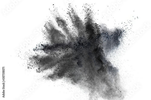 Black powder explosion against white background.The particles of charcoal splattered on white background.