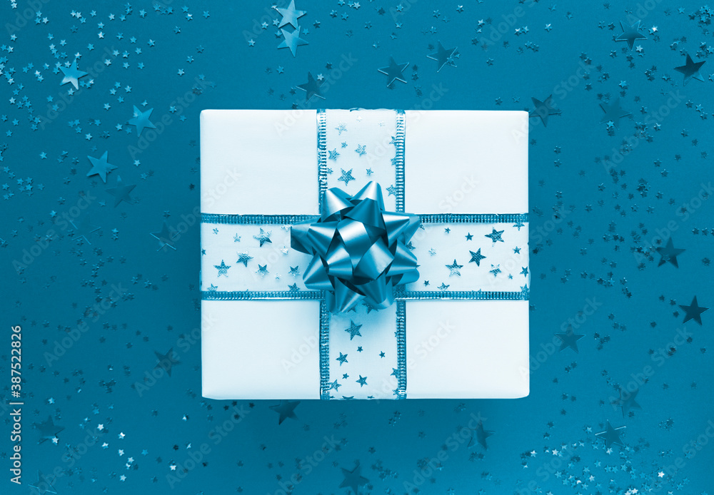 Gift box and stars on a blue background. Monochrome flat lay. Gift box and stars on a blue background. Monochrome flat lay.
