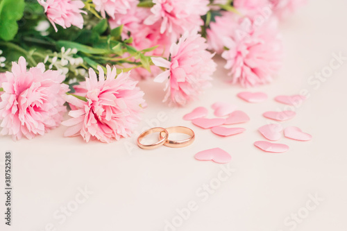 Pair of wedding rings surrounded by hearts and flowers