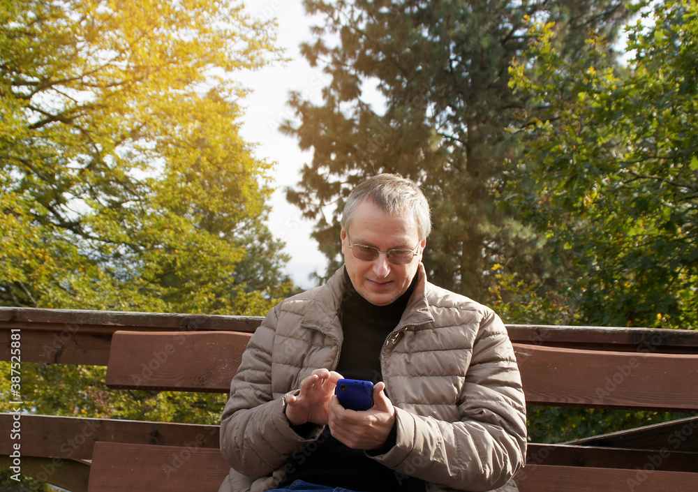 man holding a phone in the autumn forest man holding a phone in the autumn forest