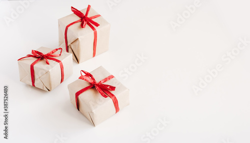 Gift boxes made from craft paper with red ribbon on white background with space for text.