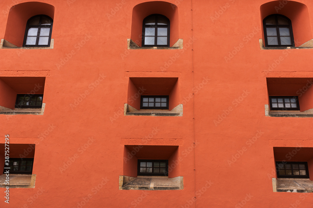 Orange facade with small windows. Architectural background