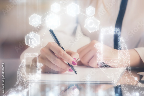 Technology theme hologram over woman's hands taking notes background. Concept of Tech. Double exposure