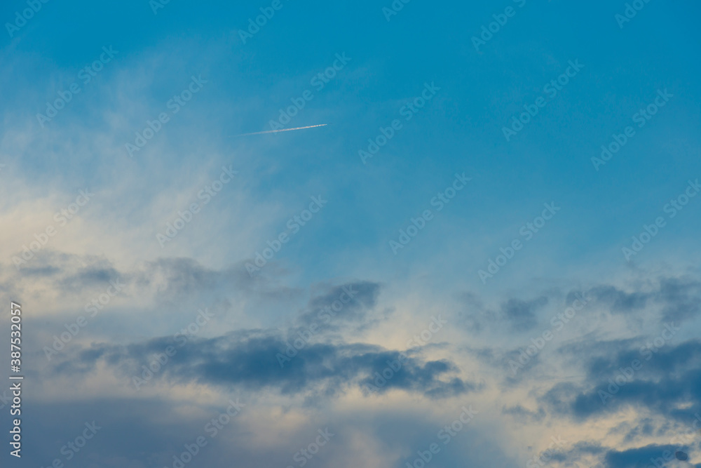 Airliner flying over dark, grey and white rain clouds in bright sunlight in autumn, Almere, Flevoland, The Netherlands, October 23, 2020 Airliner flying over dark, grey and white rain clouds in bright sunlight in autumn, Almere, Flevoland, The Netherlands, October 23, 2020