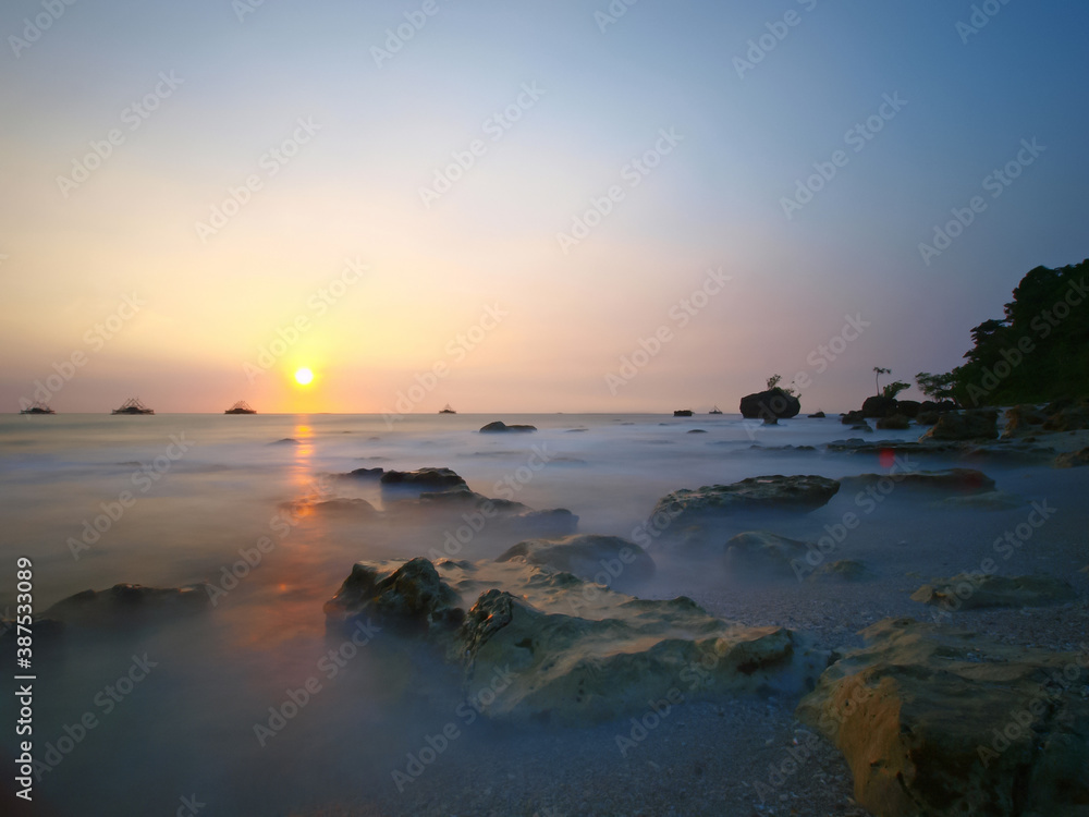 
sea ​​background, sunset with the fog crashing waves hitting the coral reefs