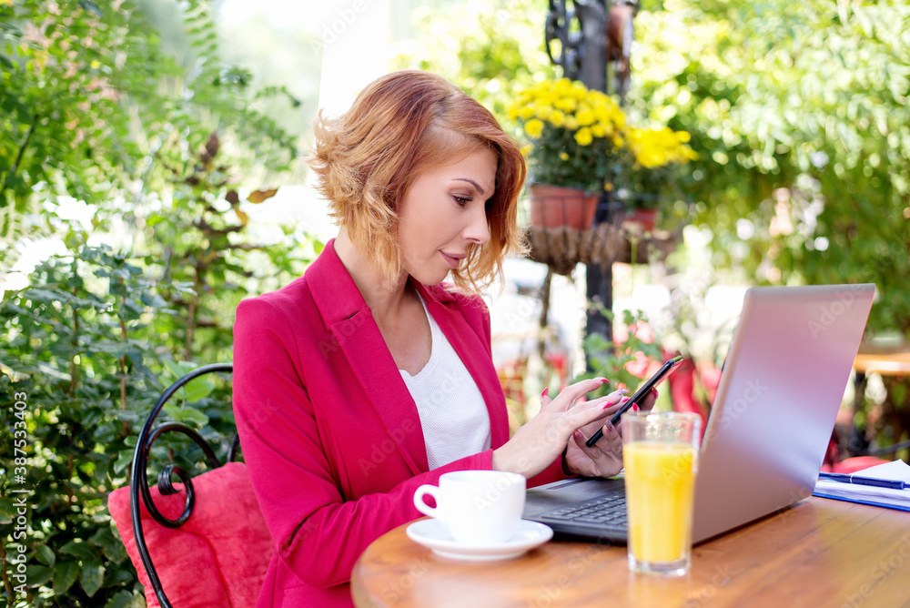 Business woman talking on mobile outdoors in cafe Business woman talking on mobile outdoors in cafe