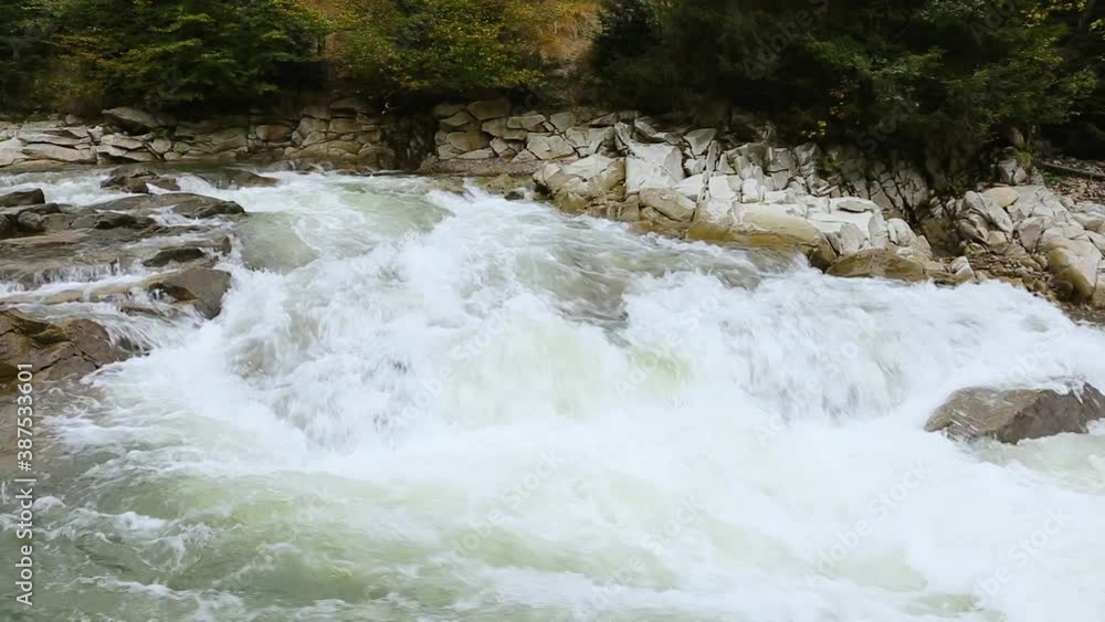 Fast mountain river in the Carpathians. Mountain rapids and gullies. Waterfall on a mountain river. Crystal mountain water. Fast mountain river in the Carpathians. Mountain rapids and gullies. Waterfall on a mountain river. Crystal mountain water.