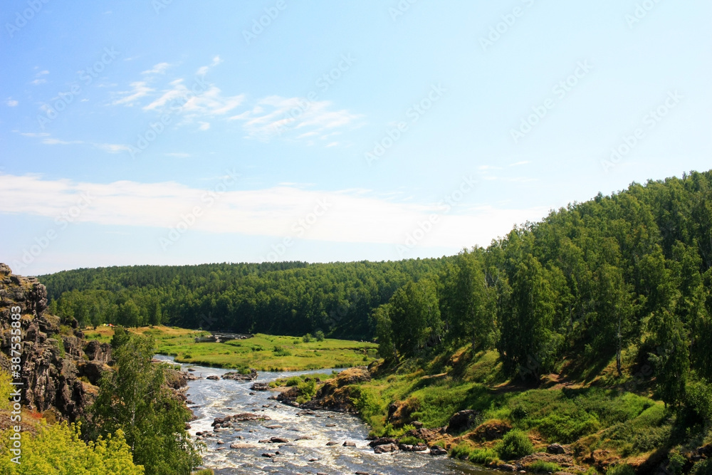 The river flows among the green banks