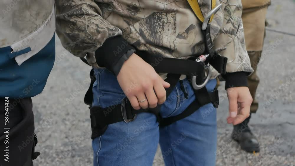 a military training instructor zips up training jumping equipment on a cadet. Special forces trainings. The equipment is put on and selected efficiently and reliably a military training instructor zips up training jumping equipment on a cadet. Special forces trainings. The equipment is put on and selected efficiently and reliably