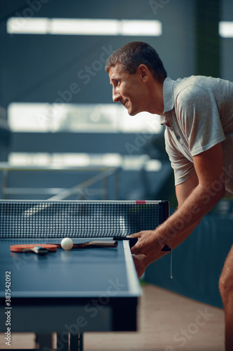 Man at the ping pong table, side view