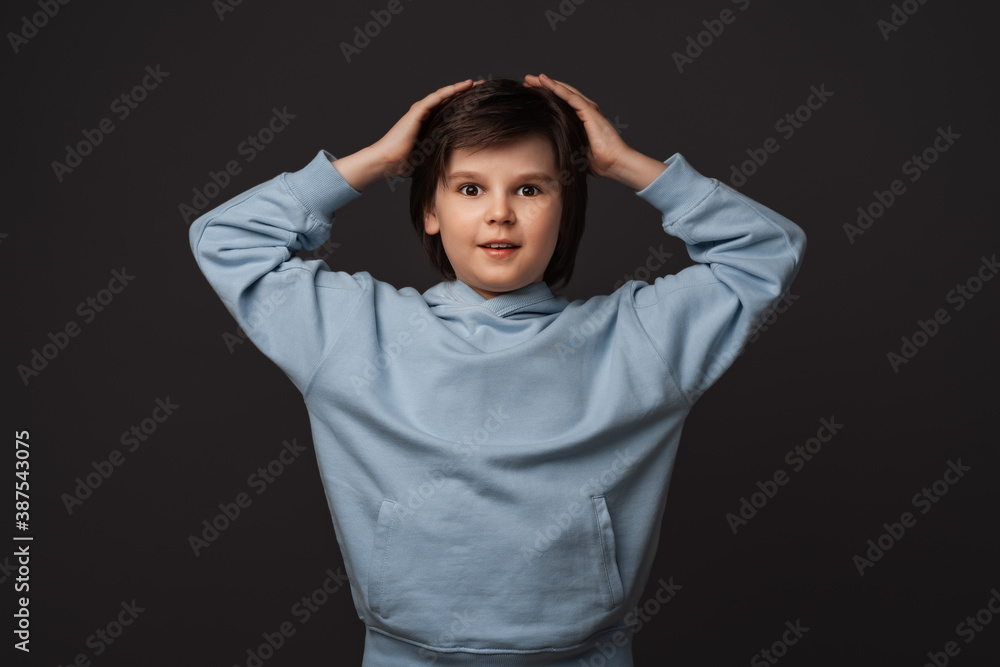 Image of shocked boy expressing surprise on camera. Studio shot, gray background. Facial expression concept Image of shocked boy expressing surprise on camera. Studio shot, gray background. Facial expression concept